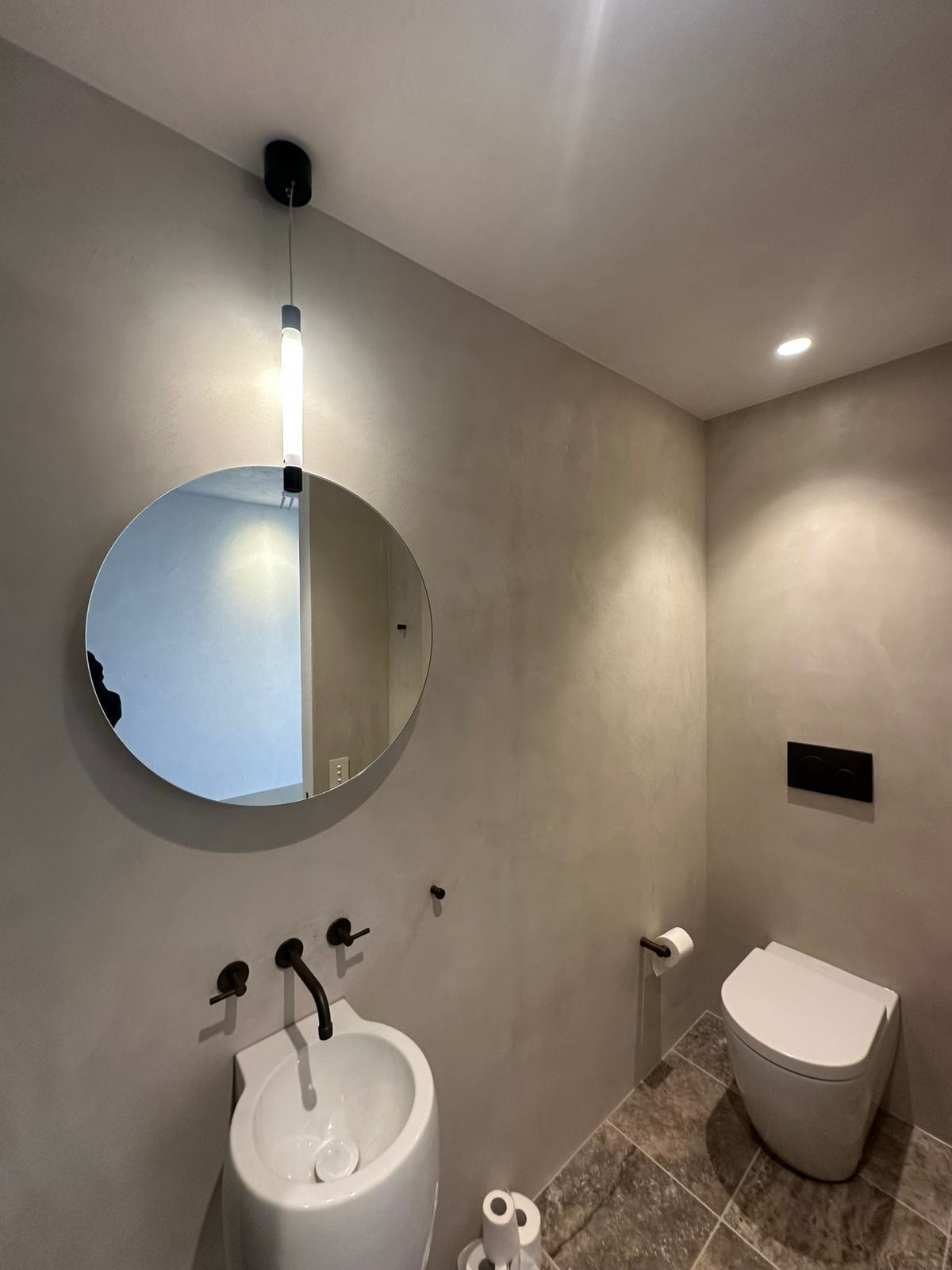 Backlit round mirror over a vanity