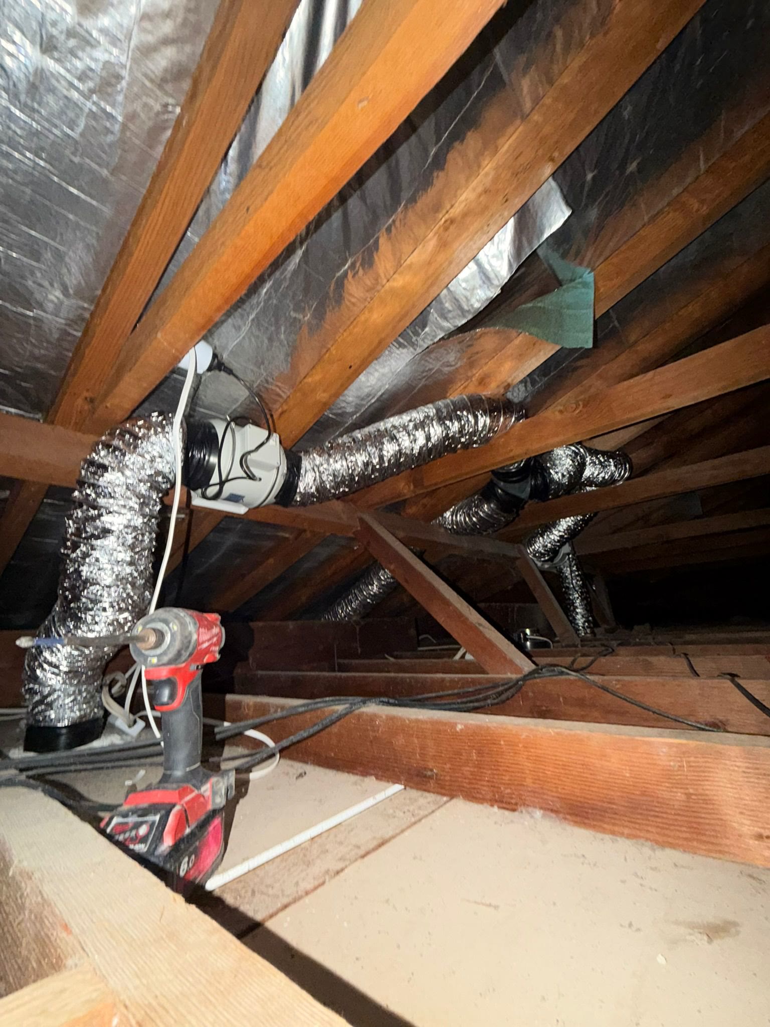Electrician tracing wiring in a roof cavity during fault finding