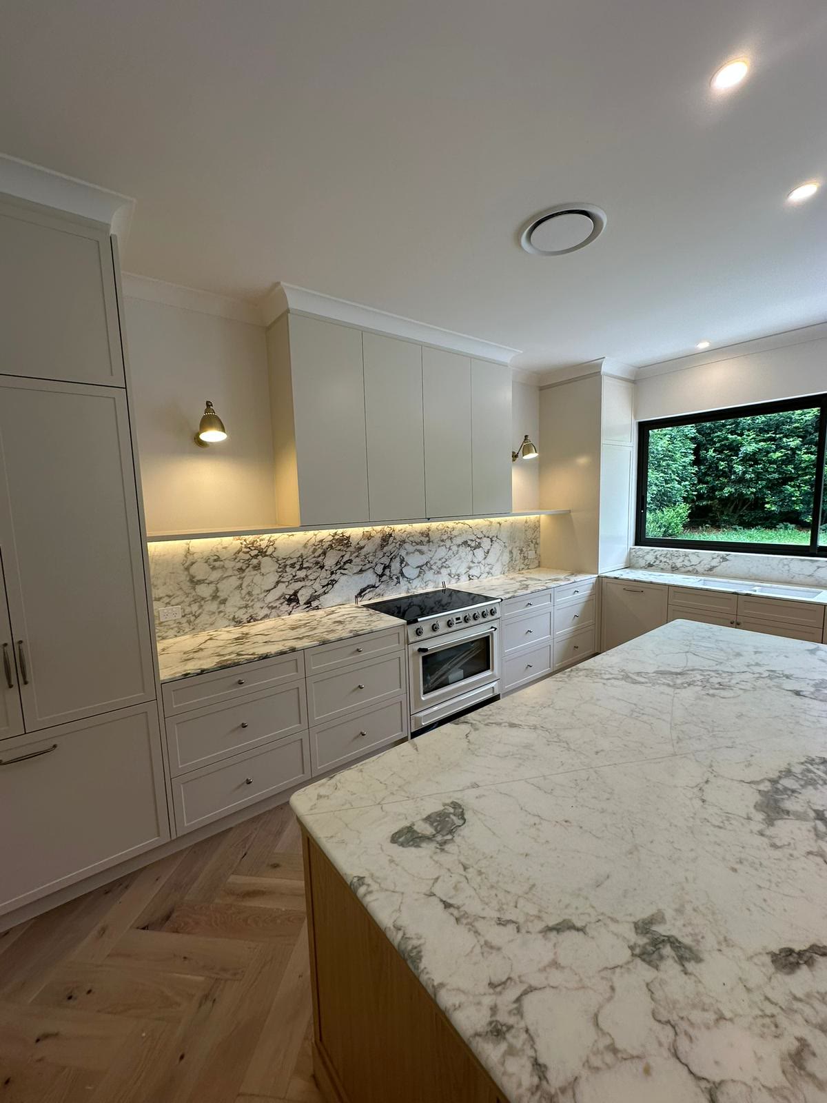 Kitchen with marble waterfall island and pendant lighting